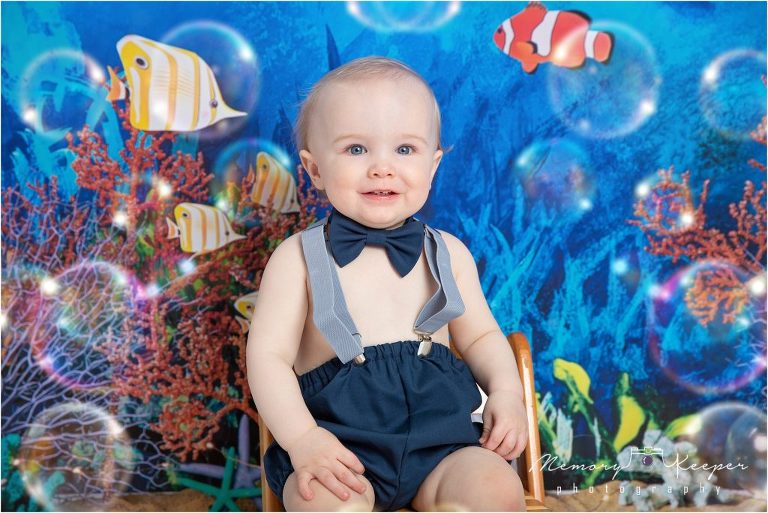Baby boy cake smash these "Oneder The Sea" Fish and bubbles surround the baby. 
