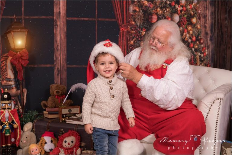 Santa Claus putting his hat on a smiling child.